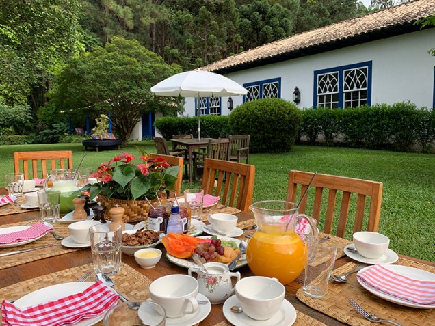 Café da manhã caprichado é servido no jardim da fazenda / Tina Bini