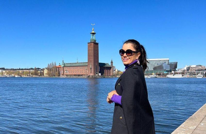 Daniela Filomeno às margens da baía de Riddarfjärden, com a Prefeitura de Estocolmo ao fundo • CNN Viagem & Gastronomia