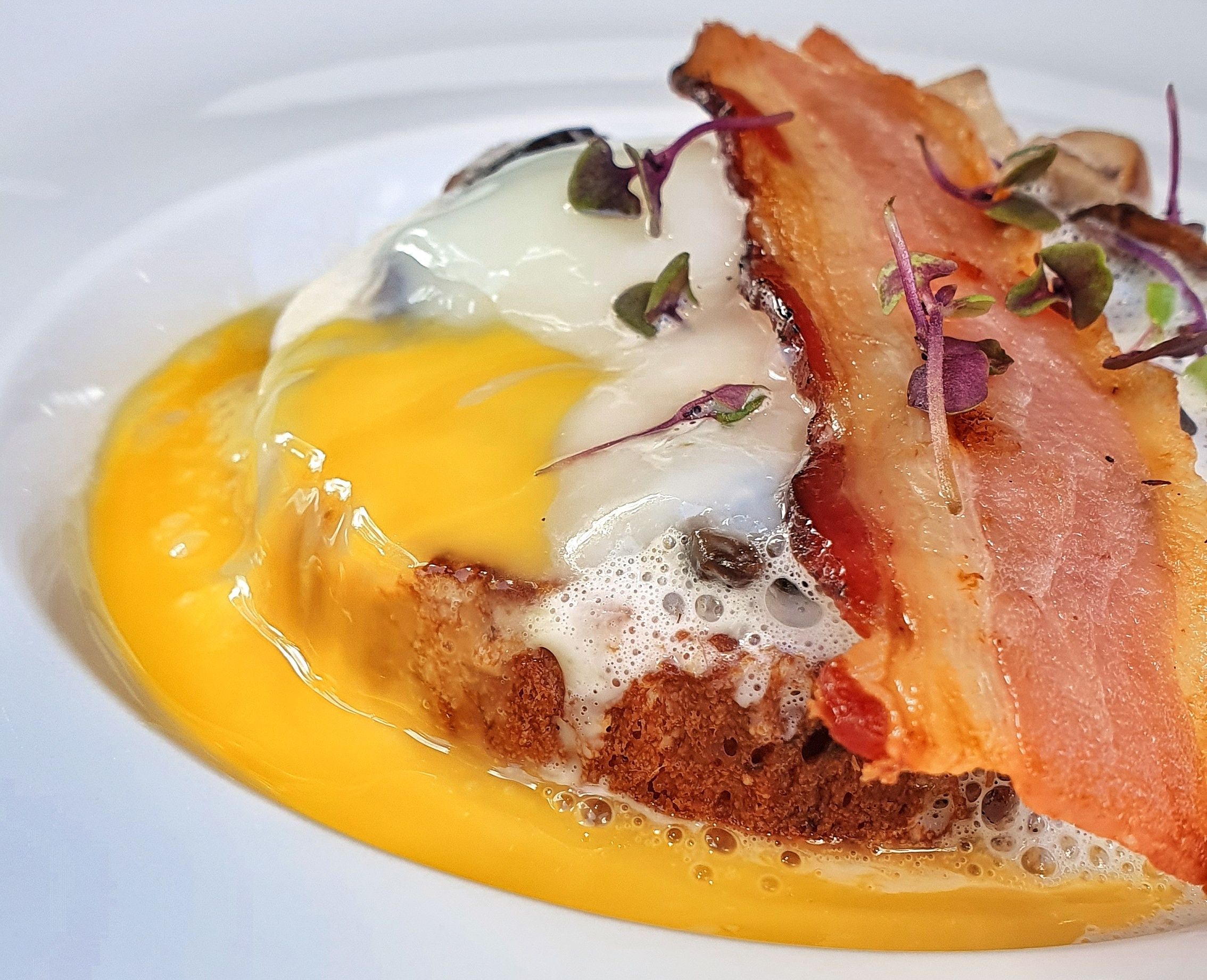 Brioche com cogumelos, ovo pochê, bacon e espuma de grana padano Nomade