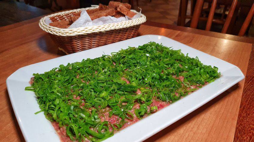 Boteco tempera carne moída com ovo cru, rum, noz moscada e páprica; mistura é para "chuchar" o pão / Caroline Grimm