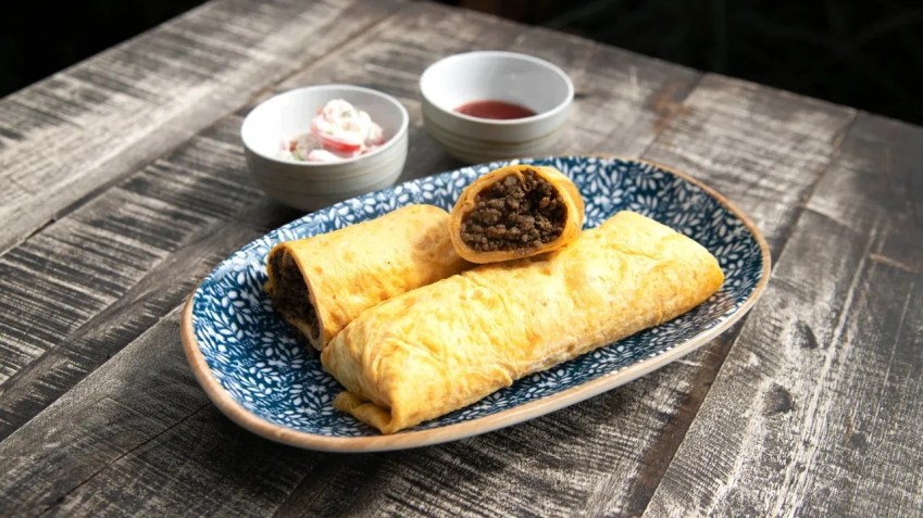 O murtabak de carne de Singapura é um crepe de ovo enrolado em carne moída servido com limão fresco, molho de pimenta e raita / Restaurant Kin