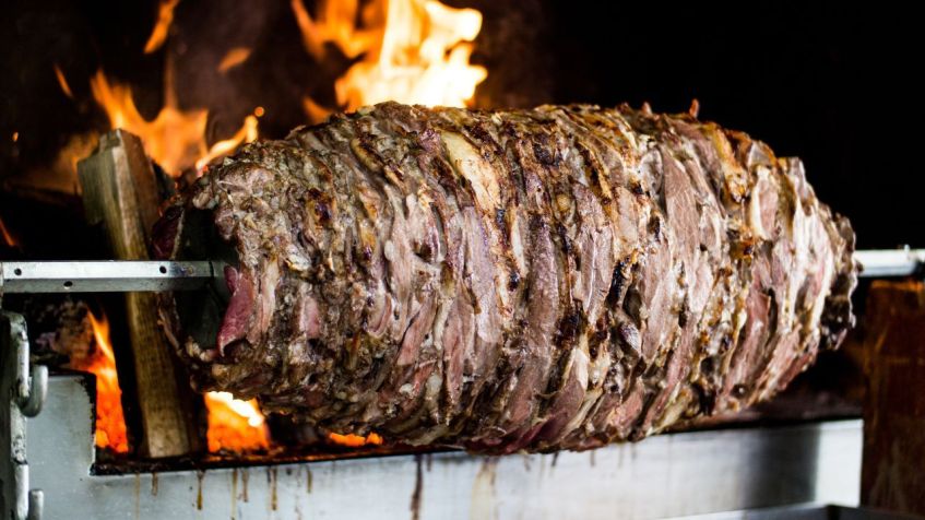Para preparar este prato, a carne marinada é assada num espeto rotativo horizontal e cozinhada em forno a lenha / Shutterstock