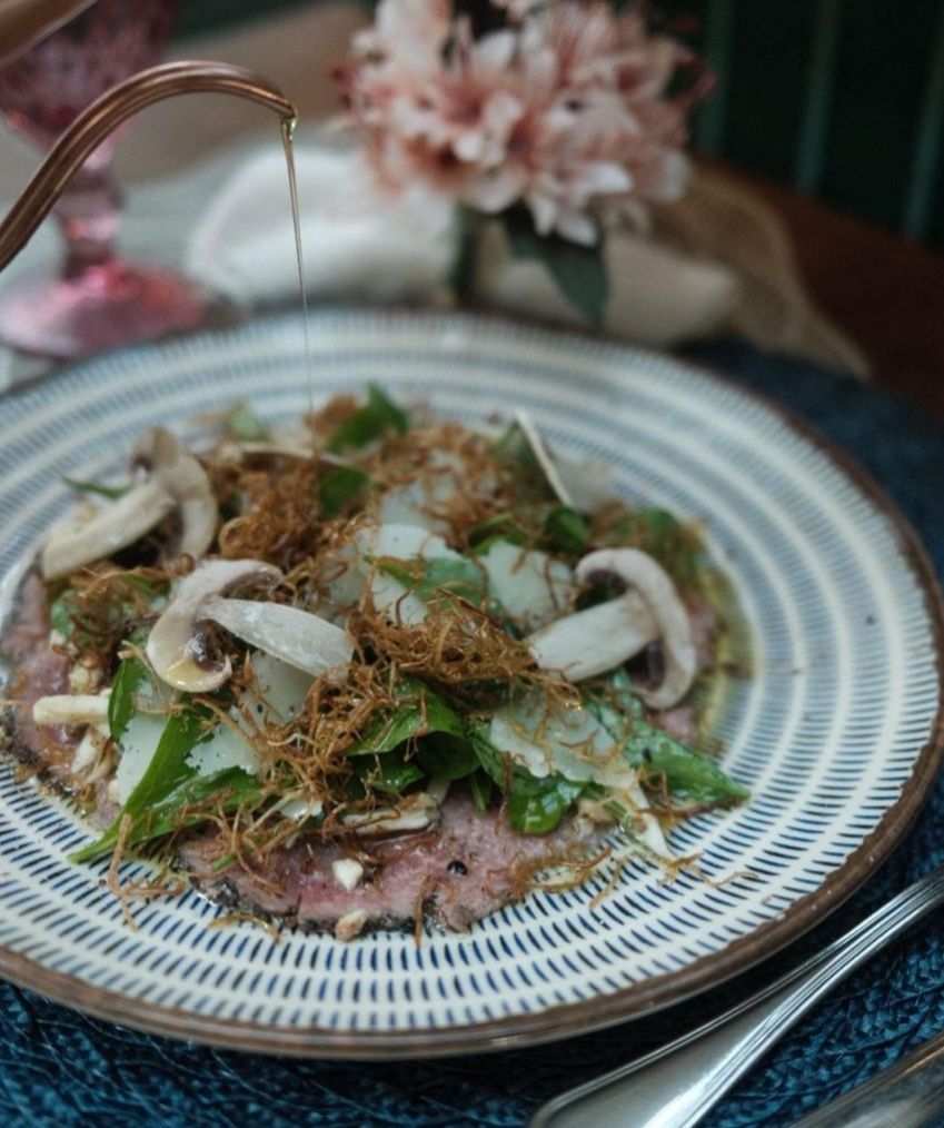 Carpaccio de Wagyu com cogumelos eryingi, alho-poró, rúcula selvagem e queijo parmesão / Divulgação