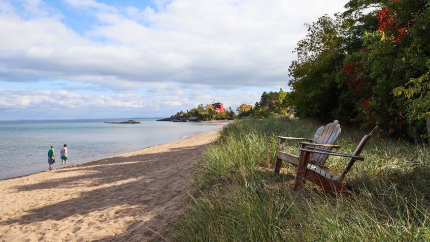 As margens do Lago Superior em Marquette, Michigan, com Harbour Lighthouse ao fundo / soupstock/Adobe Stock