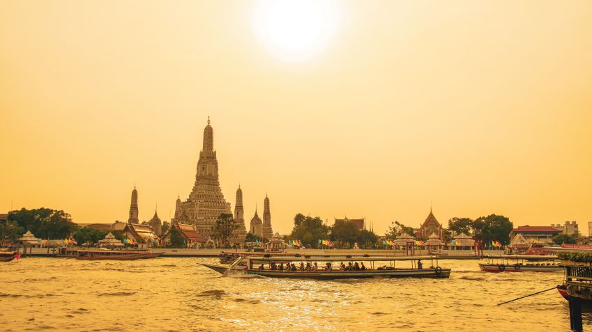 Barcos no Rio Chao Phraya, em Bangkok, com o templo Wat Arun ao fundo / Unsplash