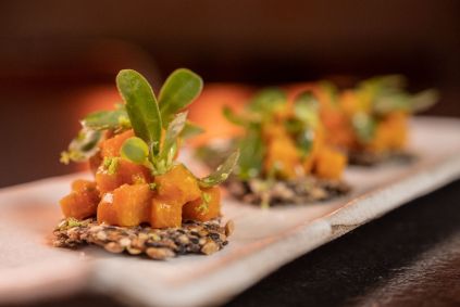Tartare de cenoura temperada com missô e beldroega sobre crocante de sementes