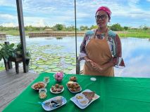Dulce Oliveira com pratos criados a partir da planta vitória-régia no Jardim Vitória-Régia, no Pará