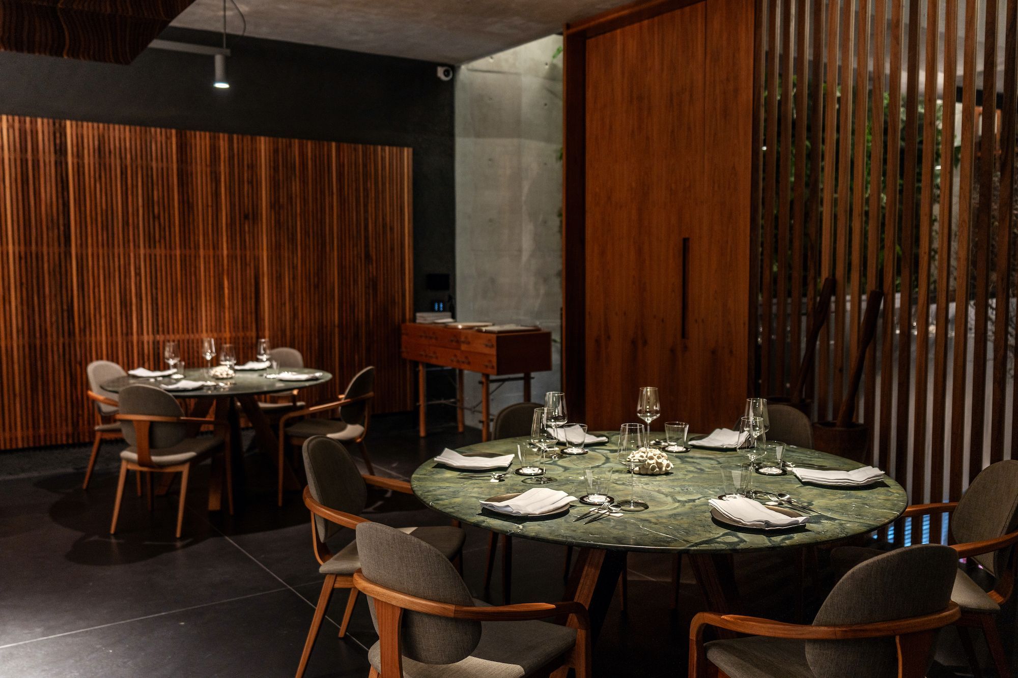 Salão principal do TUJU, onde é servido o menu degustação, tem apenas nove mesas redondas com a grande cozinha ao centro / Rubens Kato