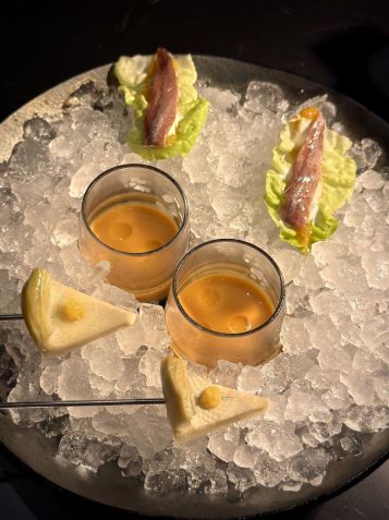 Snacks e drinques são servidos no térreo em ambiente elegante com uma jabuticabeira no centro / Tina Bini