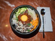 Dolsot bibimbap, mexidão coreano de arroz com carne bovina marinada, cogumelos, legumes, gema de ovo e molho levemente picante