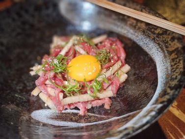 Tartar à moda coreana que combina lâminas de carne bovina e de pera nashi com gema de ovo e gergelim