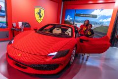 Crianças posam com o único modelo de uma Ferrari 296 GTS feita inteiramente de LEGO