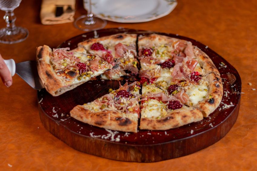 Oli serve durante Roteiro Gastronômico pizza com queijo minas artesanal da queijaria Santa Clara com muçarela de búfala, presunto cru, amora, pistache e mel / Ramon Lopes