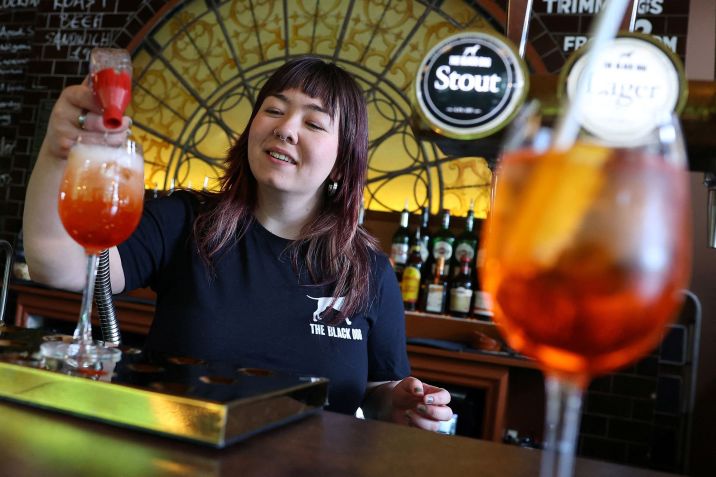 Uma funcionária do pub The Black Dog é retratada fazendo um coquetel 'Aperol Spritz (Taylor’s Version)' / oby Melville/Reuters via CNN Newsource