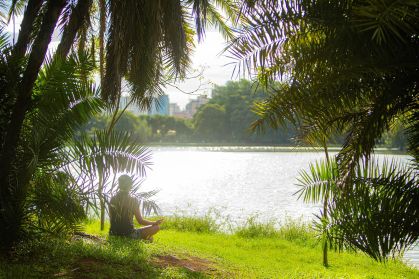 Pessoa medita à beira do lago no Parque Ibirapuera