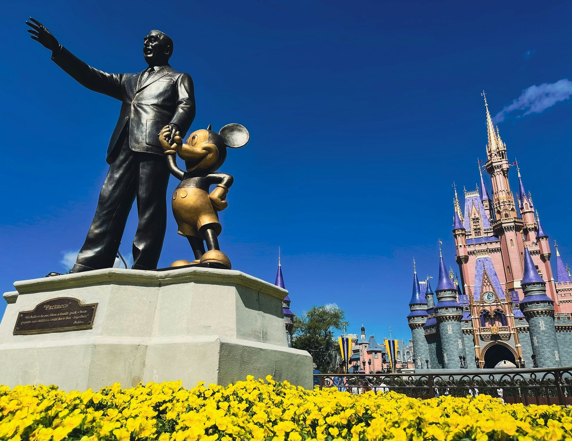 Estátua de Walt Disney e Mickey Mouse em frente ao Castelo da Cinderela no Magic Kingdom, em Orlando • Unsplash