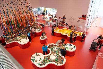 Peças de Lego e pessoas na Zona Vermelha da Lego House, na Dinamarca