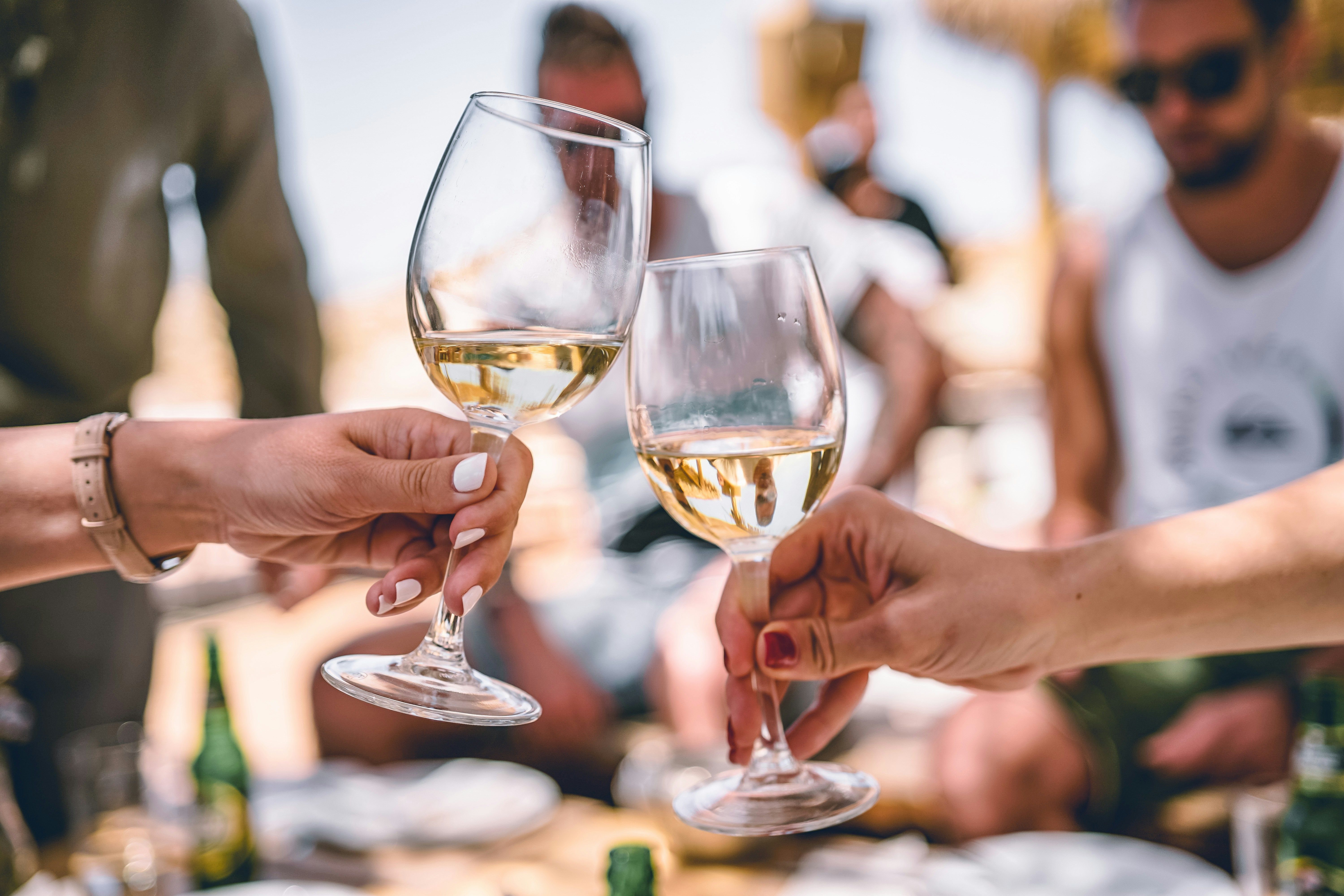 Pessoas brindando com vinho branco