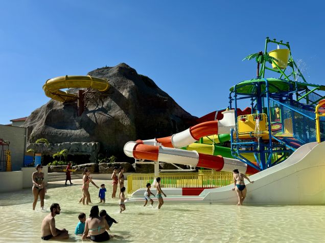 Famílias se divertem na área molhada da ilha; ao fundo, parte da montanha-russa aquática • Saulo Tafarelo