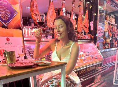 Daniela Filomeno segura taça de vinho sentada em um restaurante em Sevilha, na Espanha