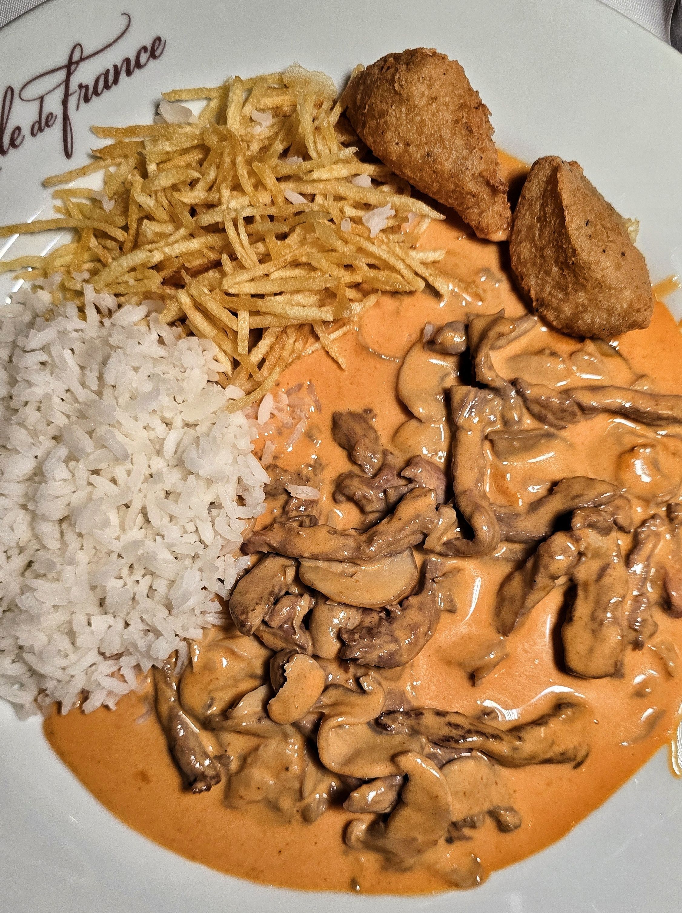 O estrogofe do Ile de France vem com arroz branco, batata palha e bolinhos de batata, e é servido na mesa / Caroline Grimm
