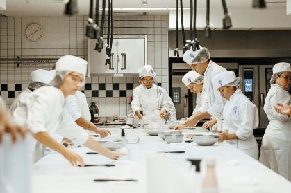 Alunos da escola Le Cordon Bleu na cozinha durante curso