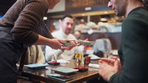 garçonete servindo comida na mesa