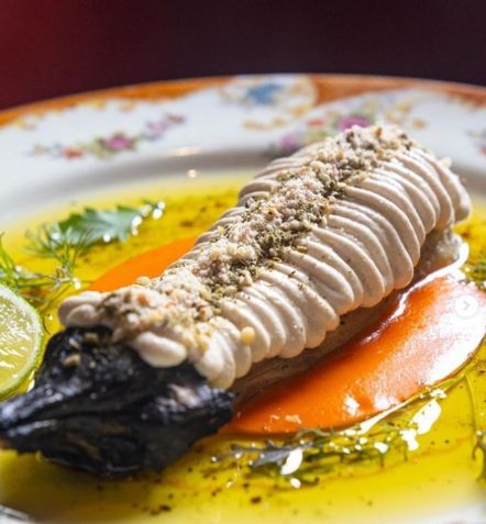 Berinjela defumada na lenha temperada com tahine, coulis de tomate, amêndoas tostadas, limão e azeite / Divulgação