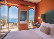 Cama e varanda do Quarto Superior do Hotel Villa Ducale, em Taormina, na Itália