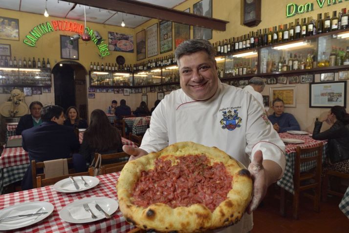 Fábio Donato com a pizza Castelões, grande sucesso da casa que completa 100 anos em outubro de 2024 • Divulgação