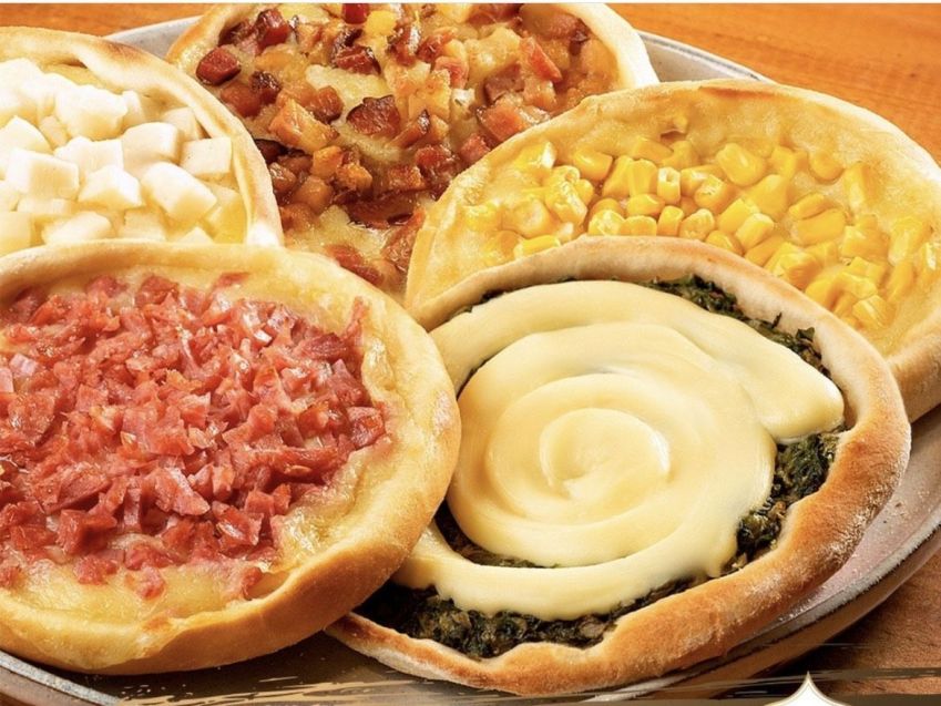 Esfihas abertas da Esfiha Imigrantes ganham diferentes sabores, como calabresa, escarola com catupiry, bacon, palmito, entre outras variações • Reprodução Instagram Esfiha Imigrantes