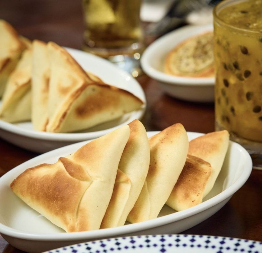 Mini esfihas fechadas do Almanara, com massas leves, crocantes e recheadas com carne, ricota ou verdura • Reprodução Instagram Almanara