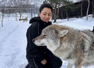 Daniela Filomeno ao lado de lobo em parque no norte da Noruega