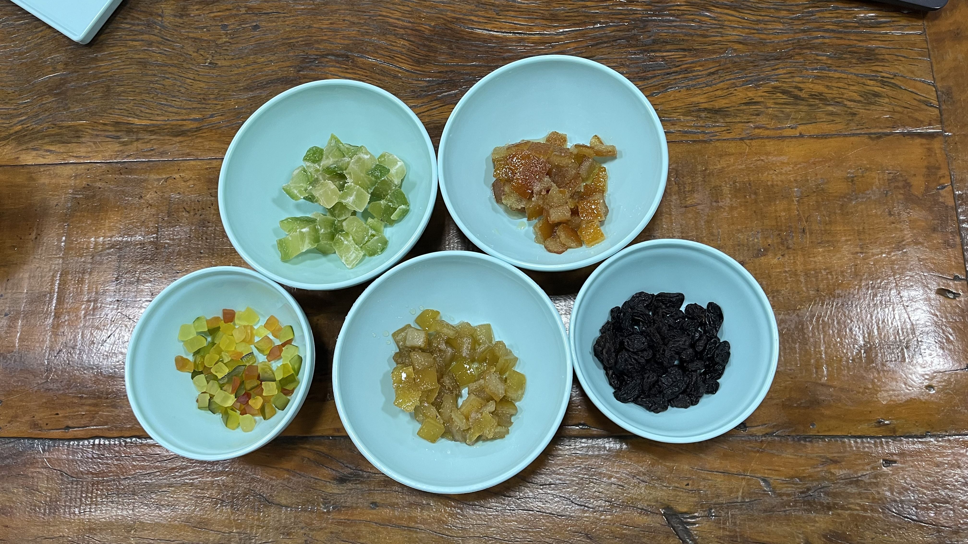 Do lado esquerdo no canto inferior é possível observar as frutas cristalizadas encontradas em panetones industrializados. Ao lado, nos outros recipientes estão Laranja, Limão, e Cidra glaceados  que dão um sabor diferente ao panetone tipicamente de Milão • Daniela Caravaggi