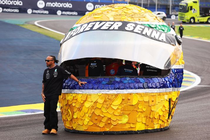 Lewis Hamilton posa em frente a um capacete gigante do Ayrton Senna, na Fórmula 1, em outubro de 2024 • Lars Baron - Formula 1/Formula 1/Getty Images
