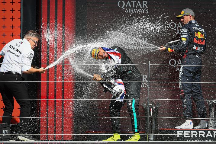 Peter Bonnington, Max Verstappen e Lewis Hamilton espalhando espumante no pódio • MI News/NurPhoto via Getty Images