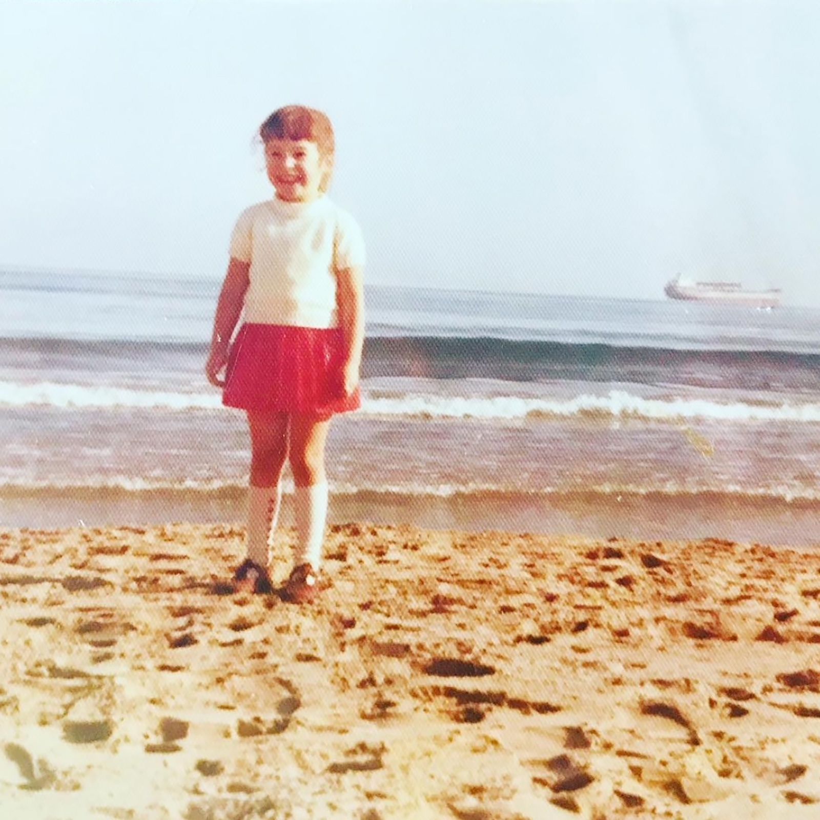 Maria fotografada na praia na cidade espanhola aos cinco anos de idade. "Voltar para cá me faz sentir como se eu tivesse reencontrado aquela garotinha na praia, que era tão feliz por estar na Espanha", diz ela • Arquivo pessoal/Maria Robertson-Justiniano
