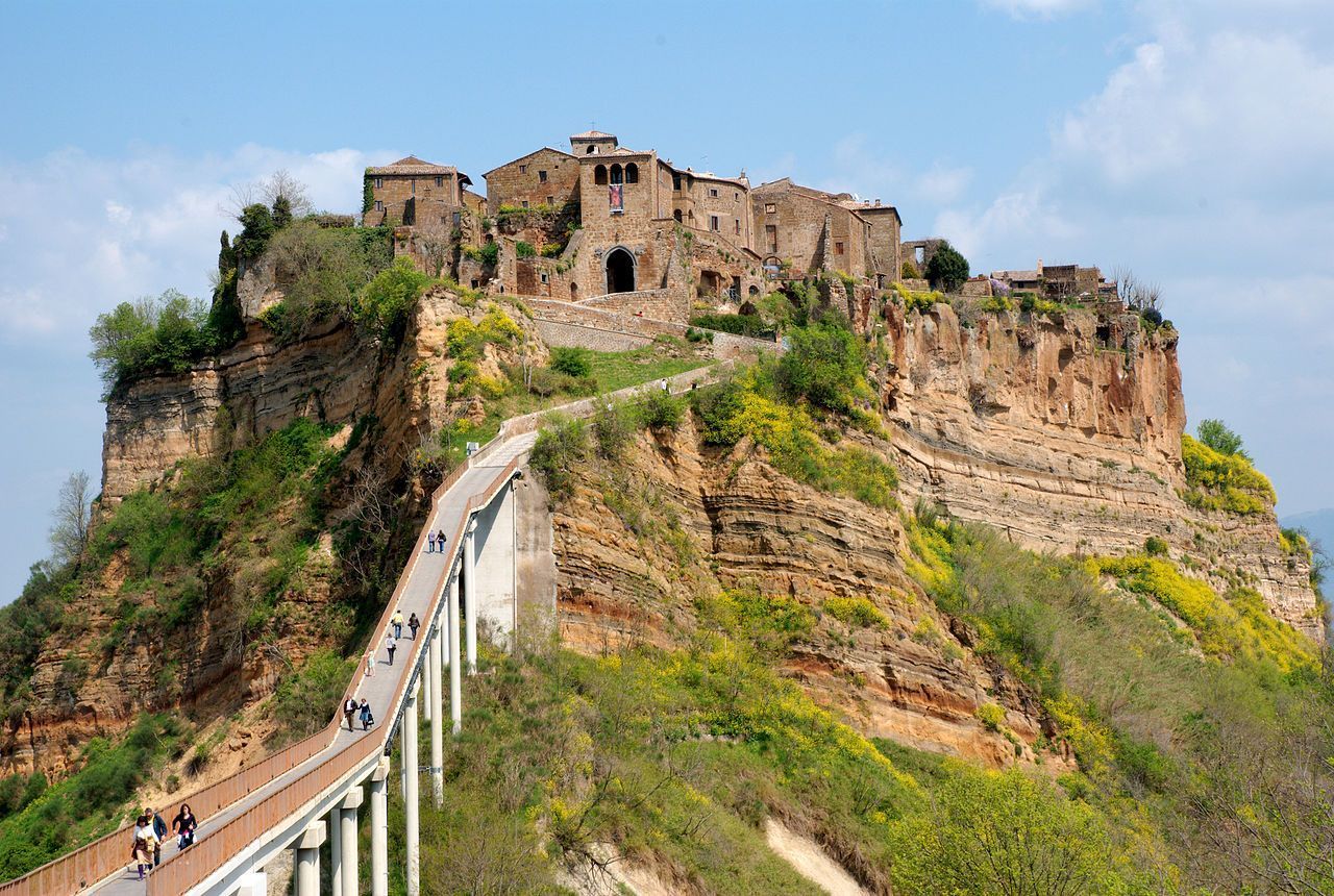 Centrinho de Civita di Bagnoregio visto de longe, com destaque para casas e torres medievais • Wikimedia Commons