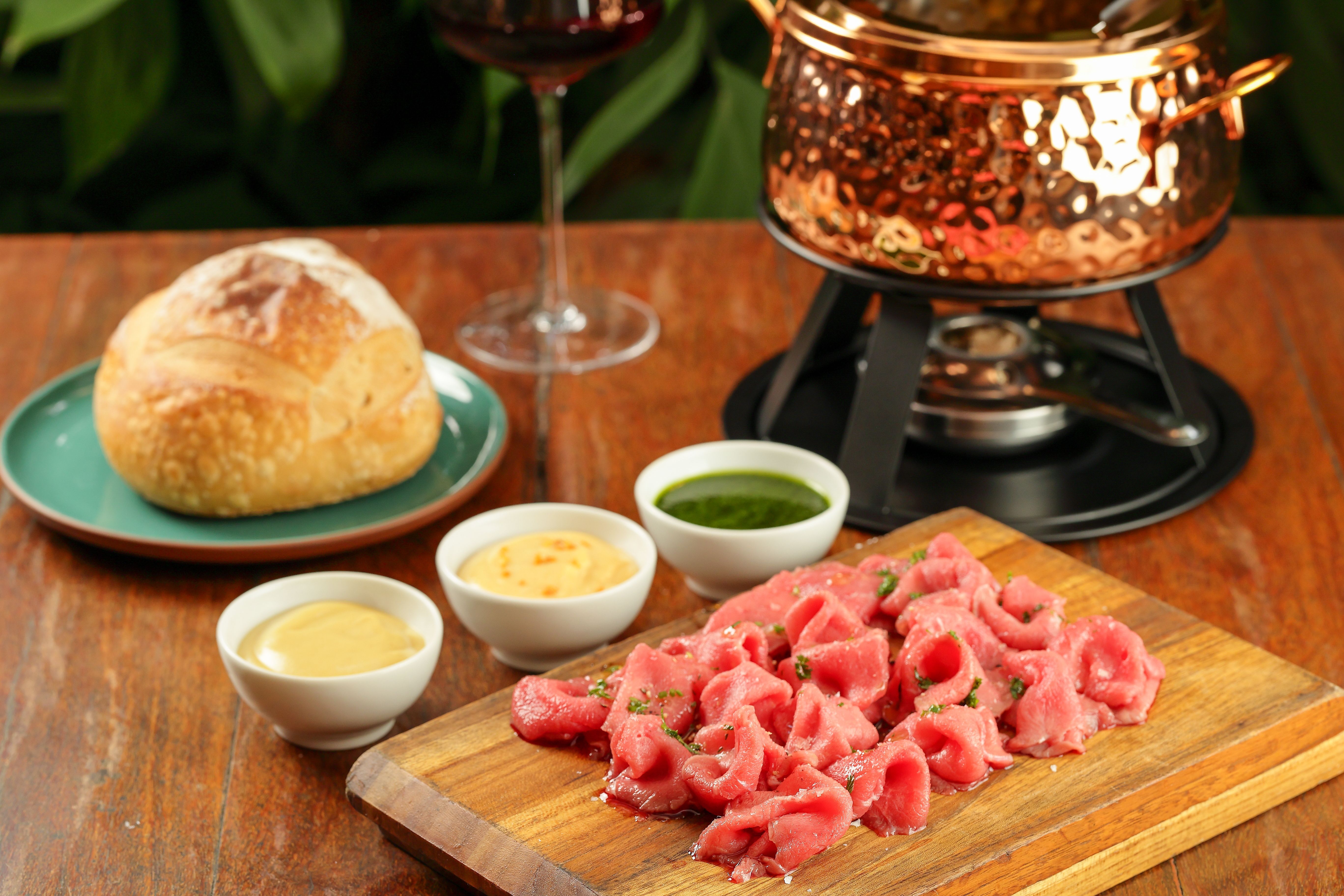 No Praça São Lourenço. a Fondue Chinoise leva finas fatias de carpaccio cozidas em consomê de carne com vinho tinto e ervas, servidas com pão italiano, torradas e molhos • Divulgação