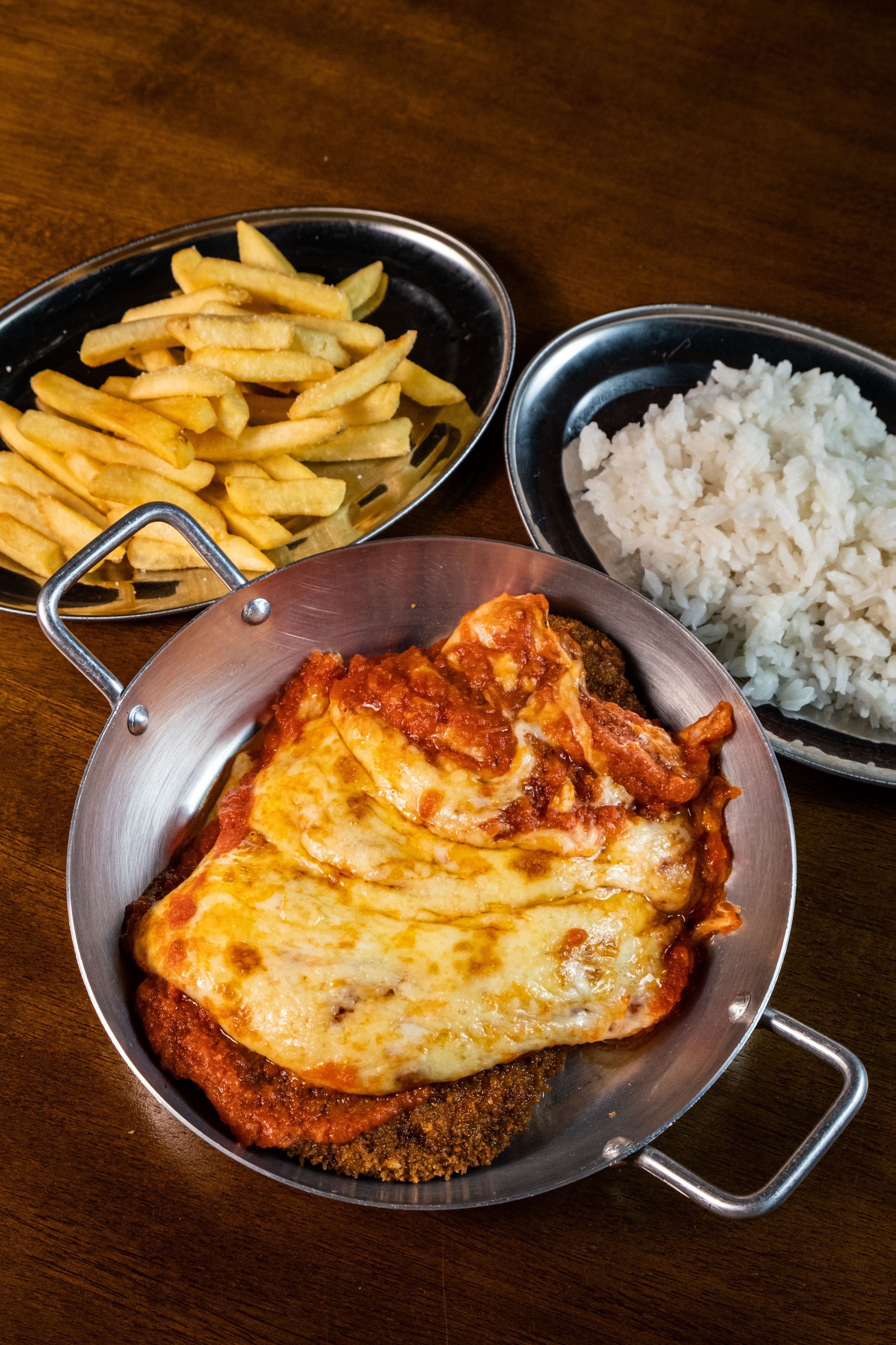 No Mula Manca, o filé à parmegiana é finalizado na mesa e serve duas pessoas • Studio Primo