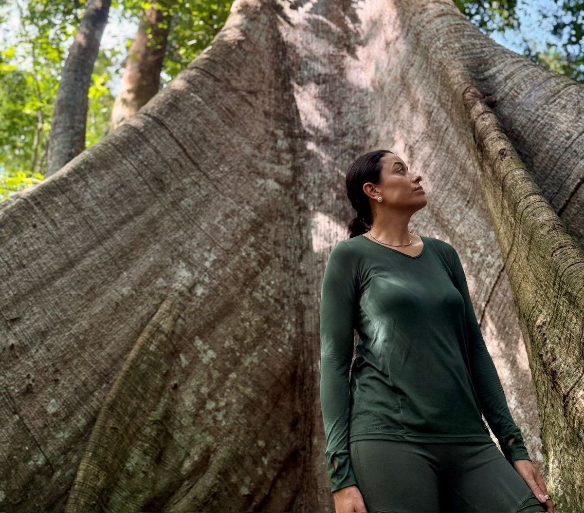 Daniela Filomeno na frente de uma árvore Samaúma