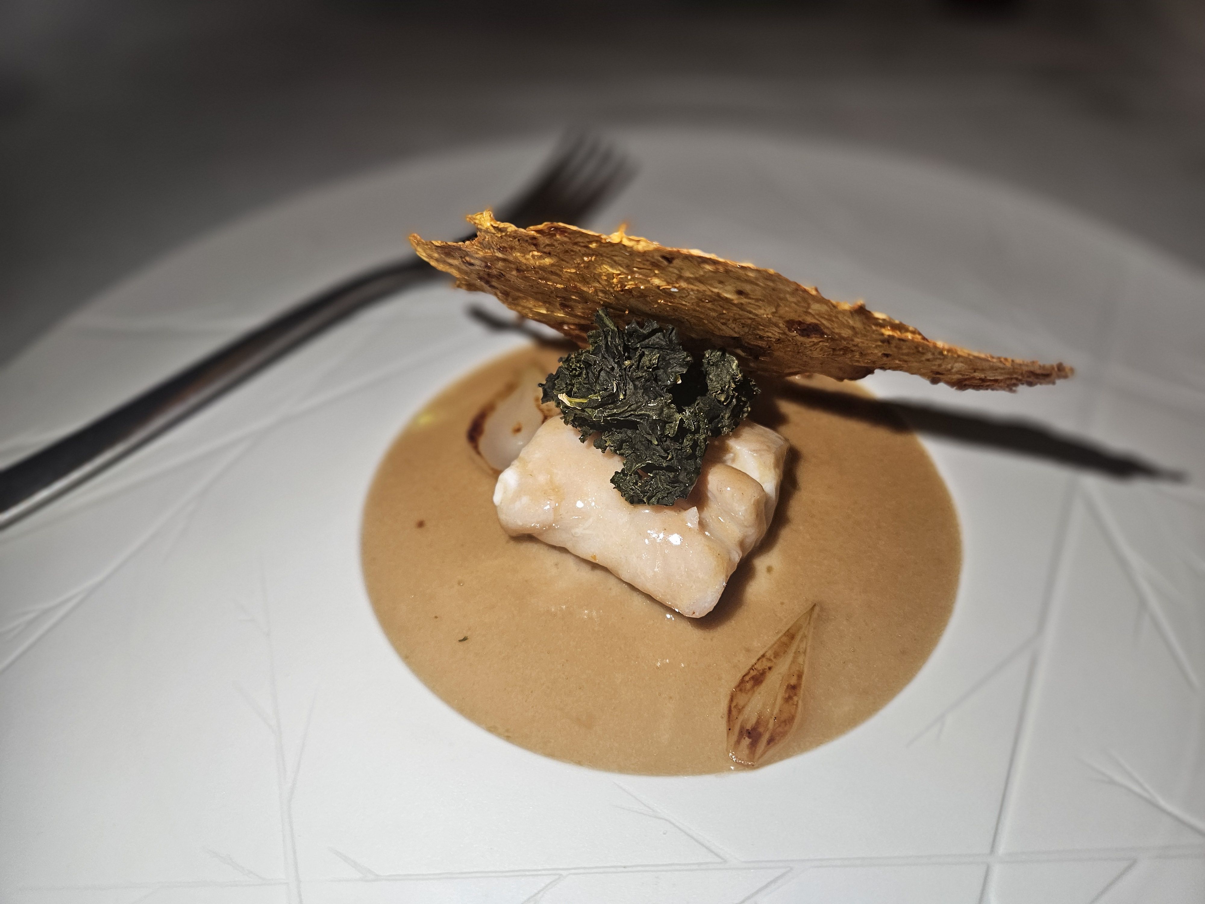 Poisson é prato que leva folha de acelga desidratada e temperada com kimchi, que "esconde" o peixe do dia, banhado por um molho beurre blanc com shoyu • Fabio Wright