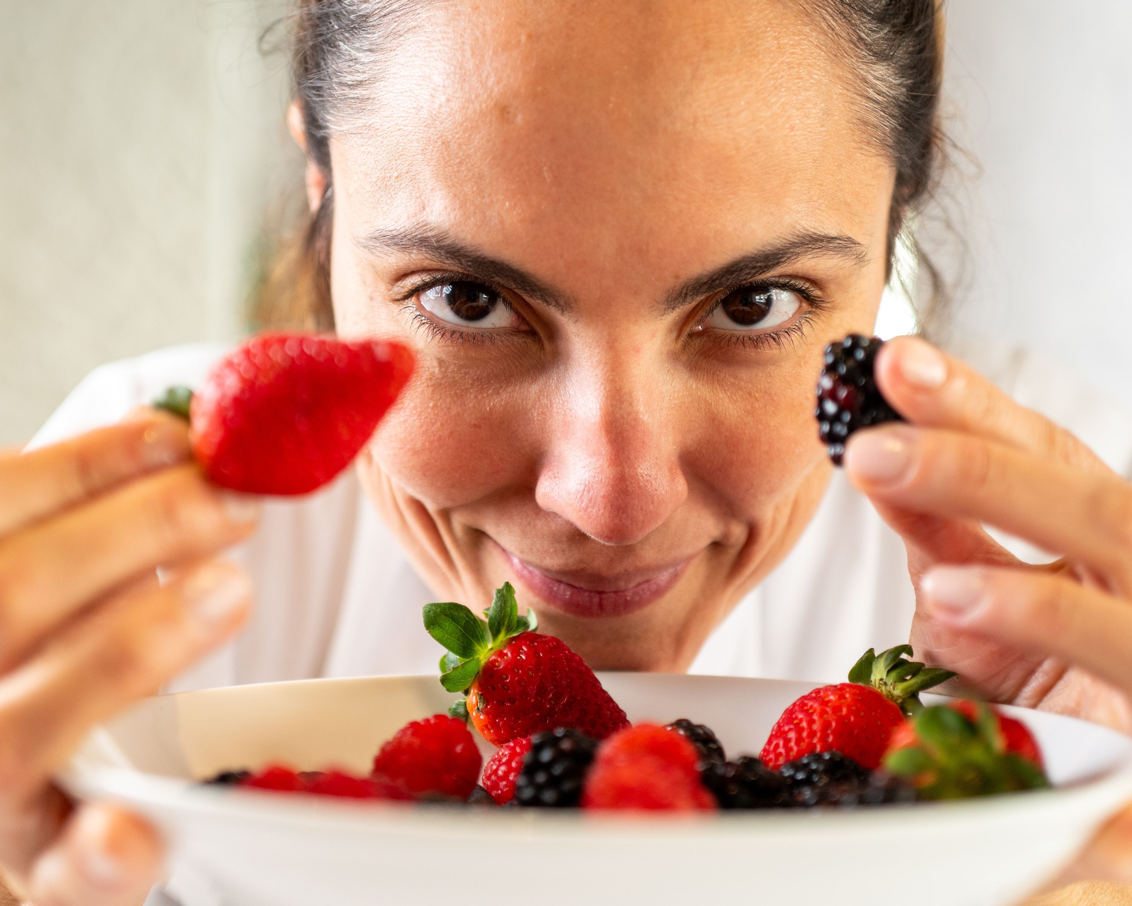 chef mariana fonseca segura frutas que estão em um prato fundo