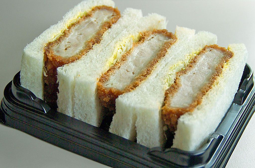 Carne de porco empanada e servida em um pão japonês branco e macio é a base deste lanche de loja de conveniência • Wikimedia Commons