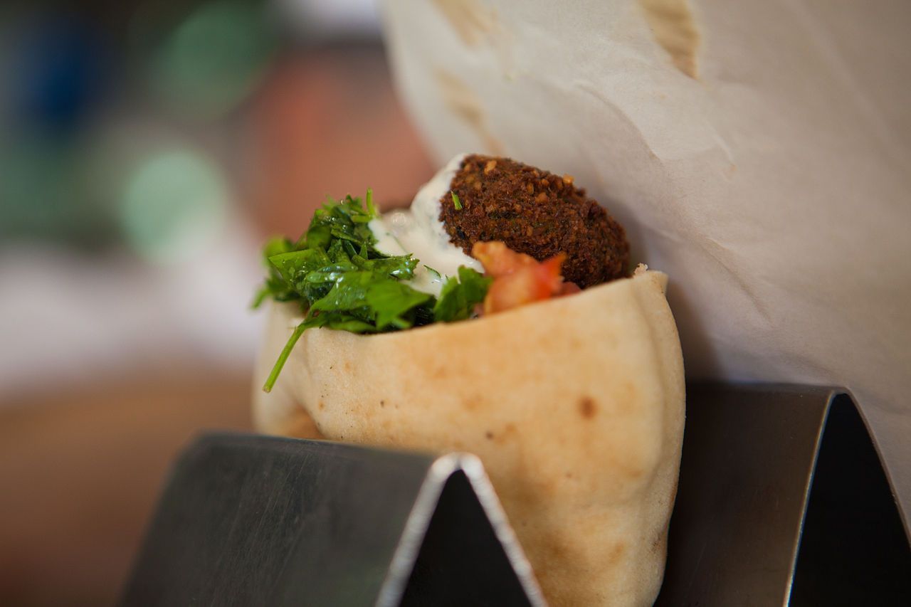 Bolinhos crocantes de falafel fritos são colocados dentro de pão pita macio e quentinho, com alface, tomate e molho tahine picante • Dana Friedlander, do Ministério do Turismo de Israel/Wikimedia Commons