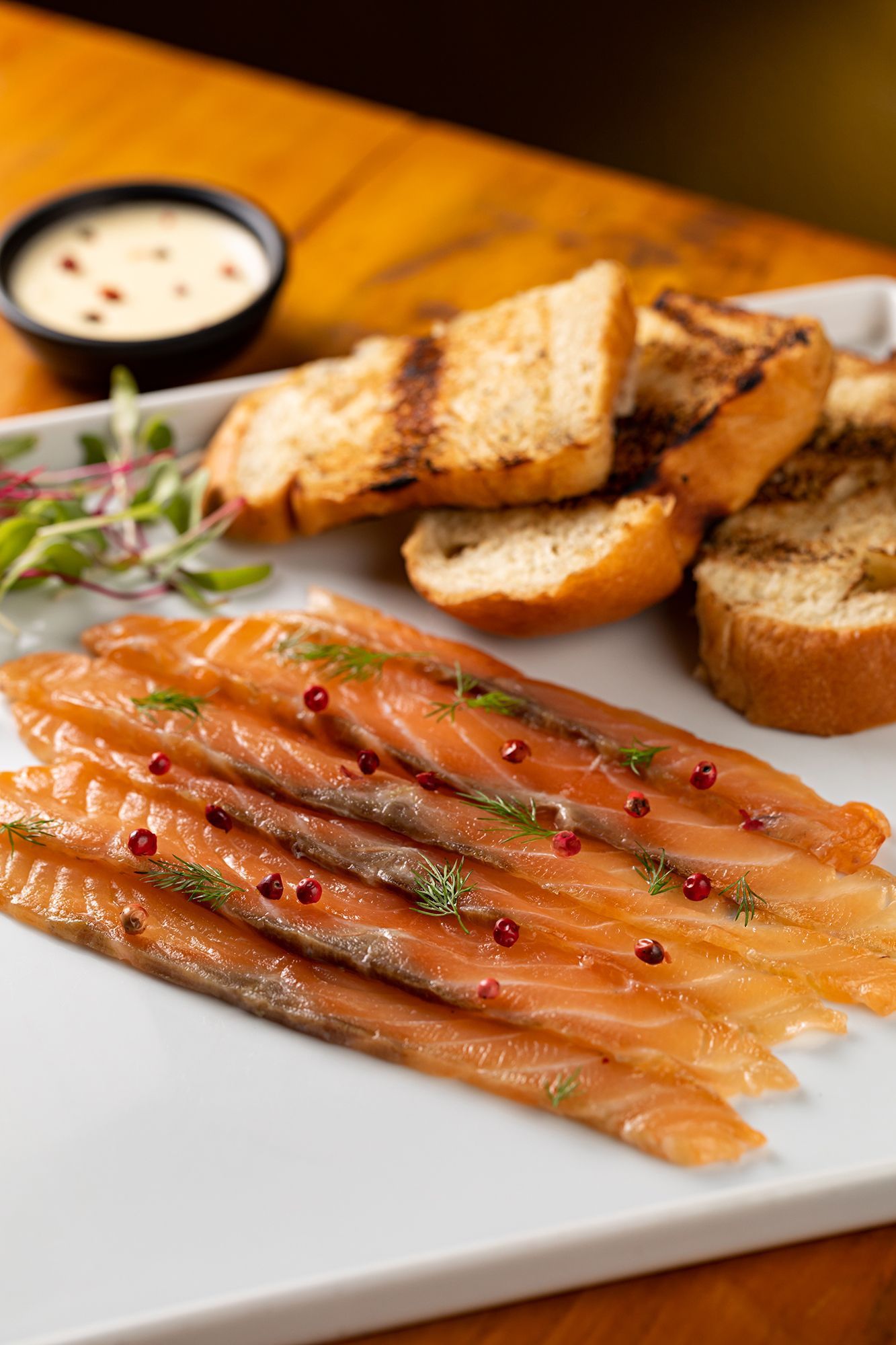 Gravlax de salmão com creme azedo de limão e brioche é encontrado no menu de Natal do La Villa • Rodrigo Azevedo