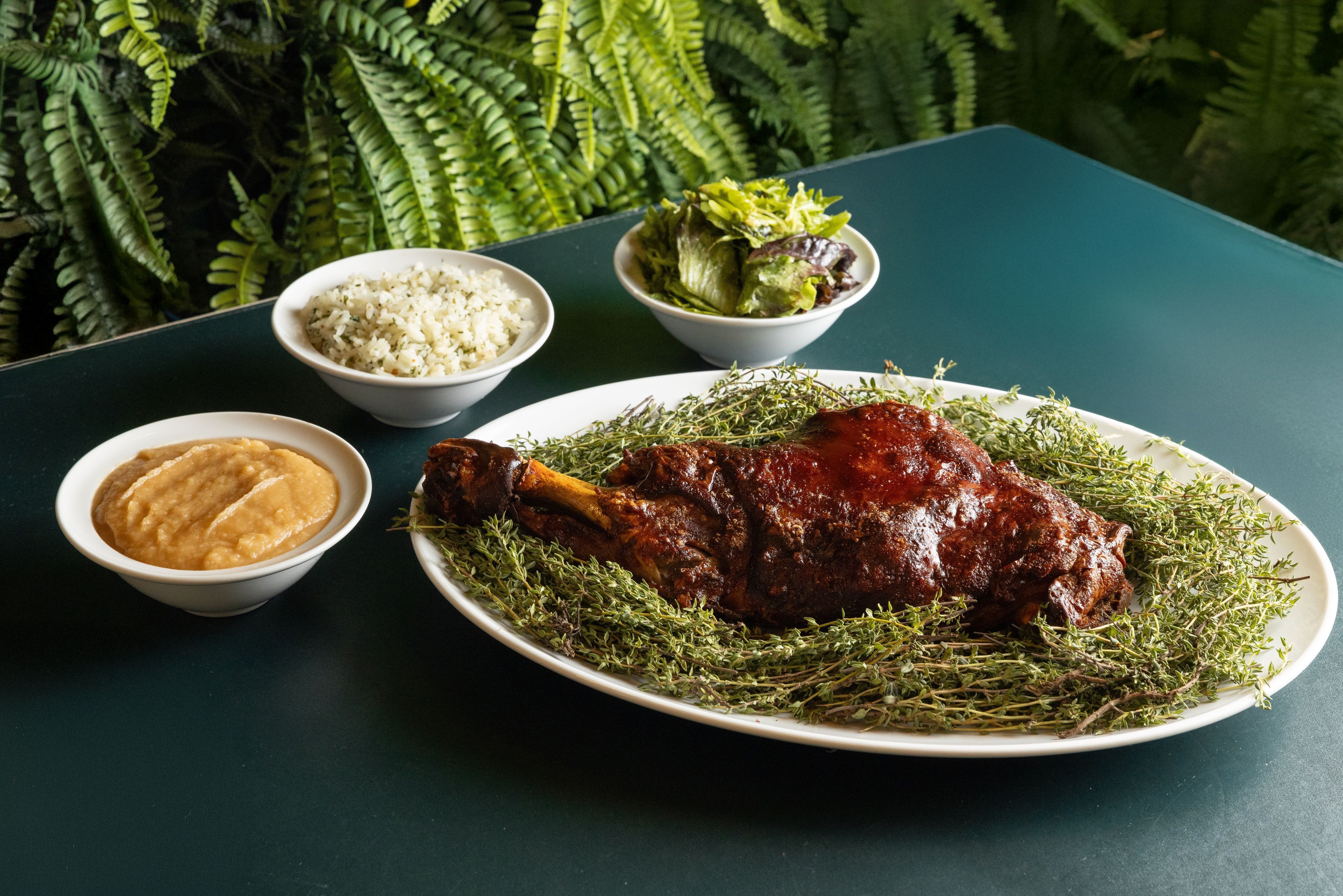 Paleta de leitoa assada acompanhada de purê de maçã, arroz pilaf e salada verde do Les Deux Magots • Divulgação