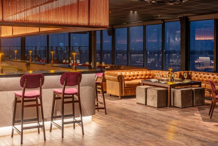 Detalhes do salão do Seen Belém, com sofás de couro e bar no centro do espaço • Divulgação