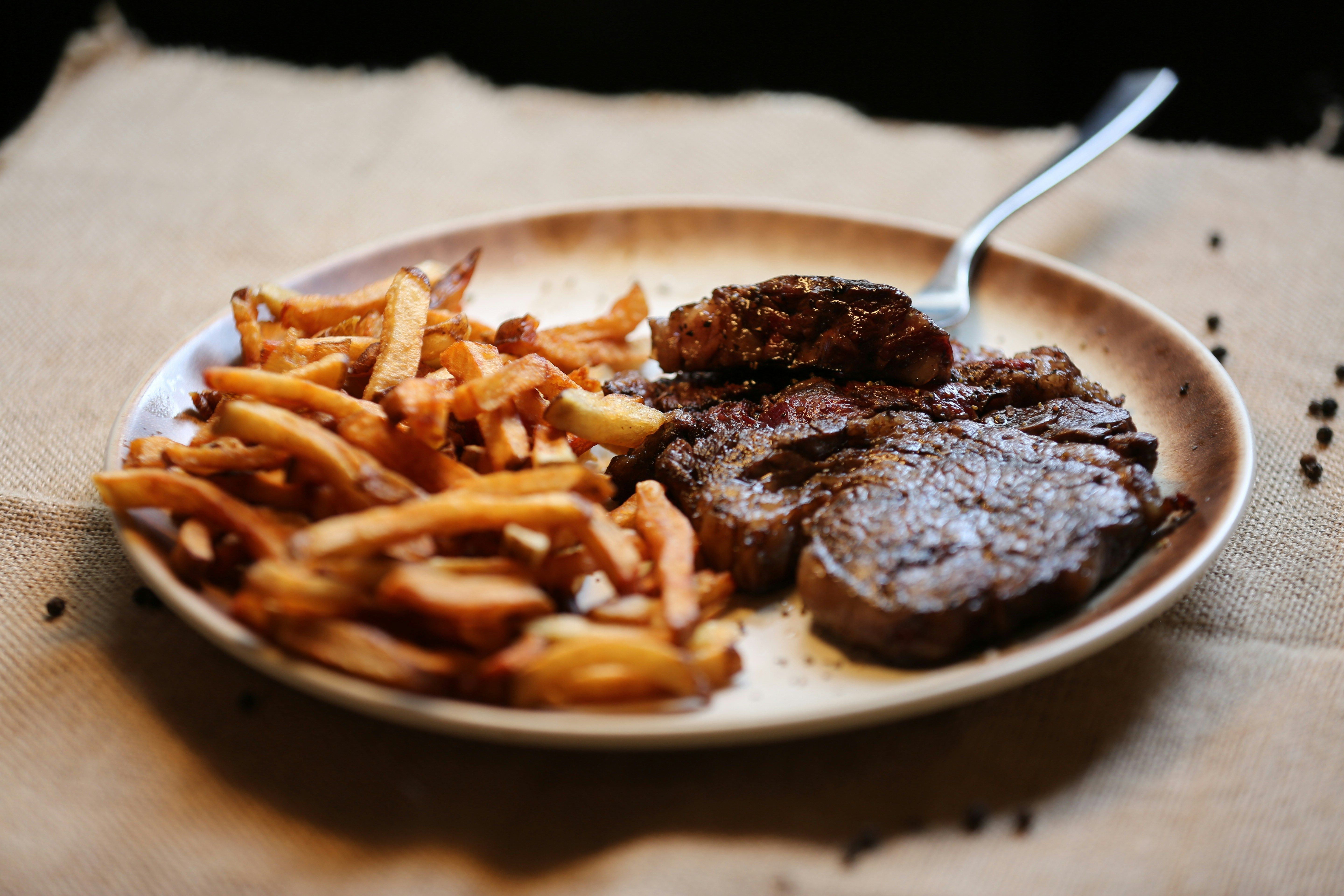 Esta refeição simples e universalmente apreciada, de bife com fritas, harmoniza bem com vinho tinto • Unsplash