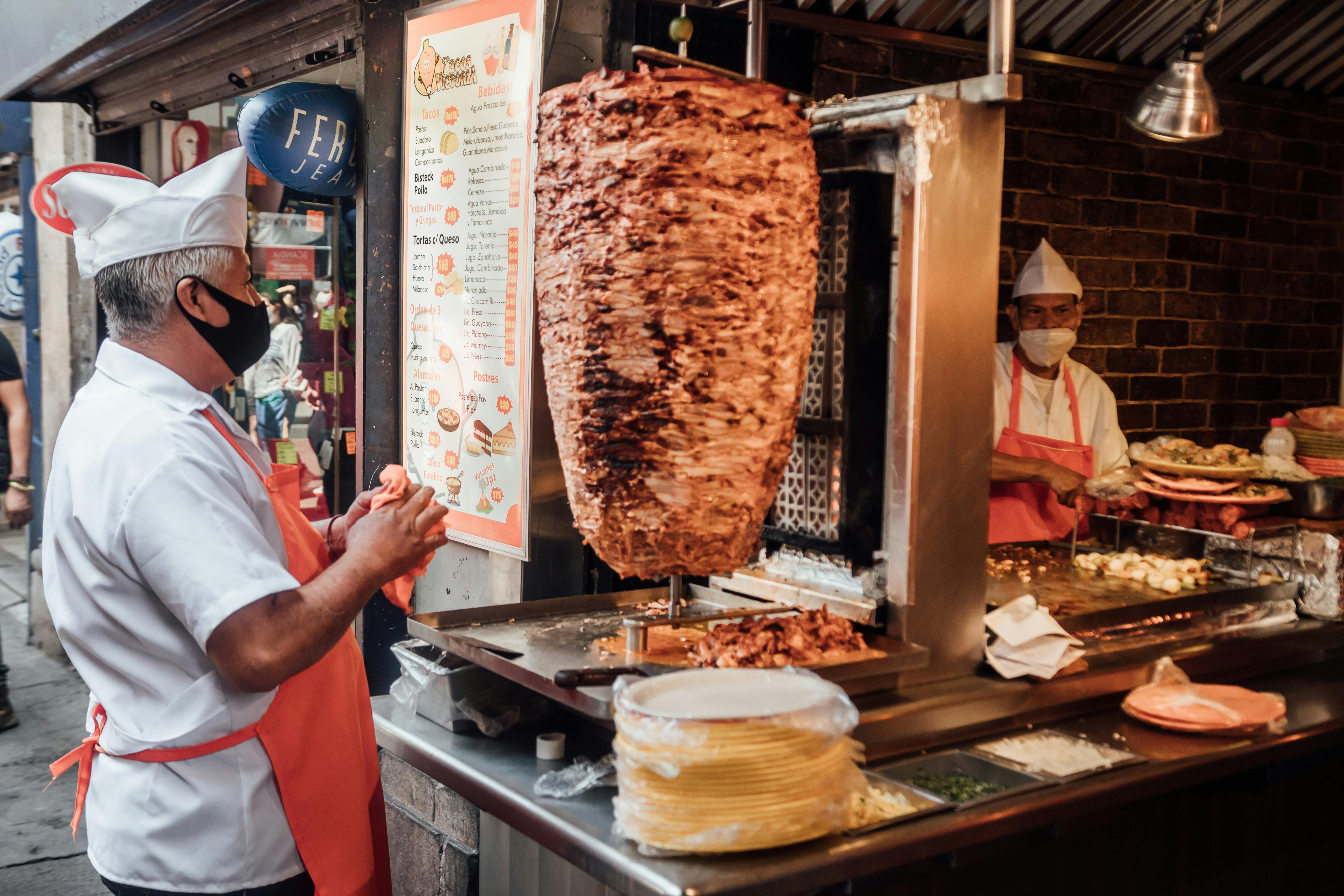 Tacos al pastor são recheados com fatias de carne de porco assadas em um espeto giratório • Pexels